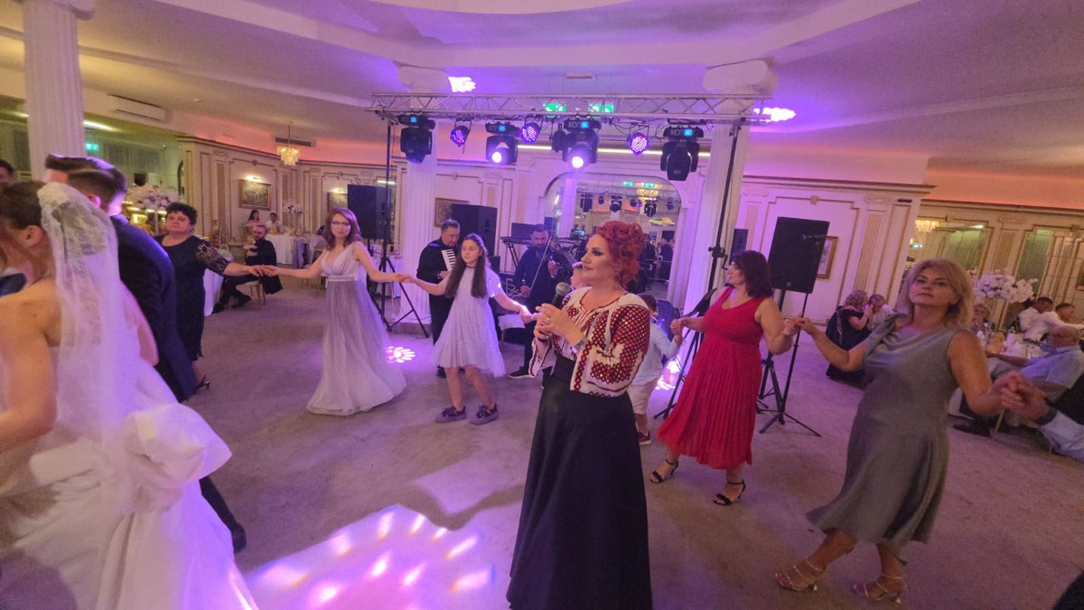 Solista cântă în mijlocul horei, alături de mireasă și invitați.